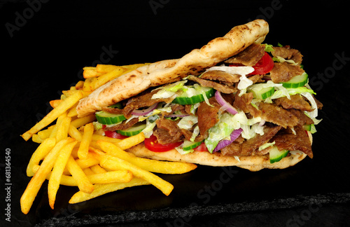 Doner kebab meat and French fries in a naan bread with salad