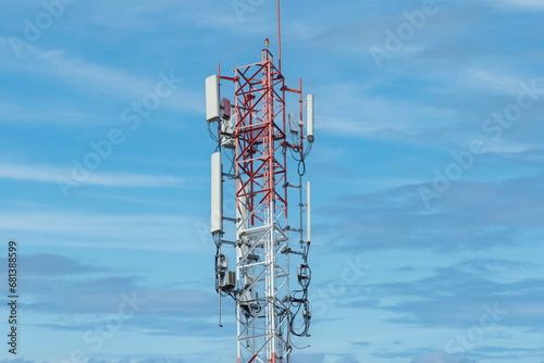 Telecommunication tower of 4G and 5G cellular. Macro Base Station. 5G radio network telecommunication equipment with radio modules and smart antennas mounted on a metal against cloulds sky background.