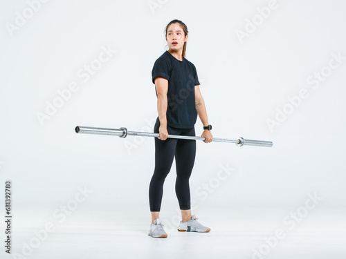 Portrait isolated cutout full body studio shot strong Asian female fitness athlete sportsman model in black casual sport workout outfit posing lifting barbell exercising on white background.