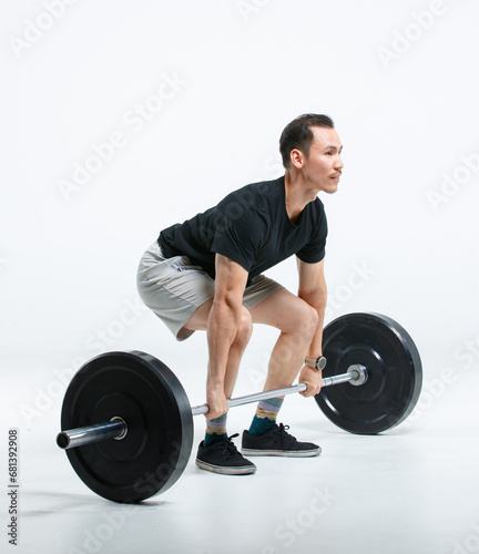 Isolated cutout full body studio shot of strong Asian male fitness athlete sportsman professional trainer model in casual sport workout outfit standing snatch lifting barbell on white background