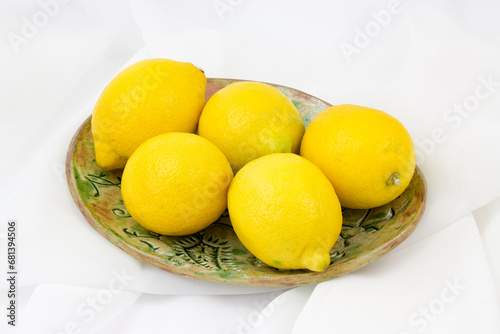 fresh lemons on a plate - white background