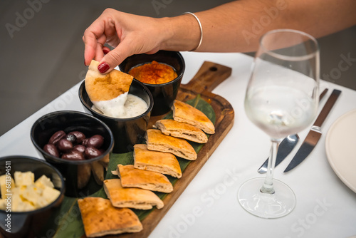 Quadro em tela Woman dipping pitta bread into sauce in a luxury restaurant
