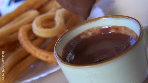 A slow-motion footage dipping Spanish churros in hot chocolate sauce. High quality 4k footage