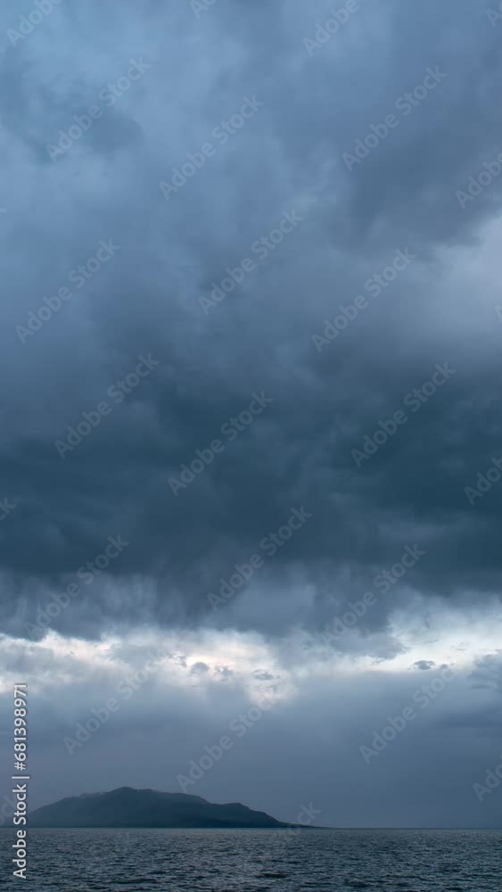 Vertical Timelapse of dramatic clouds moving over Utah Lake viewing West Mountain in the distance. Vertical Timelapse of dramatic clouds moving over Utah Lake viewing West Mountain in the distance.