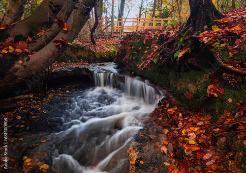 Meandering streams and small waterfalls through autumn woodland on the high weald in east Sussex south east England UK