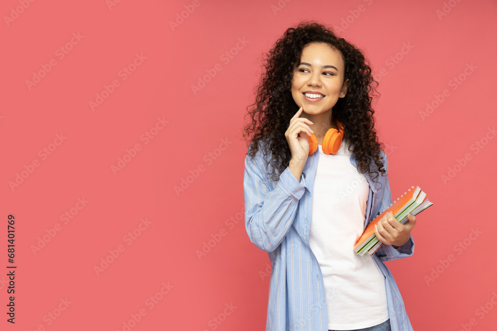 Fototapeta premium Young attractive girl with headphones on a red background