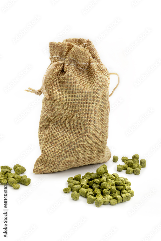 Small jute bag with pile of green hops pellets on white background.