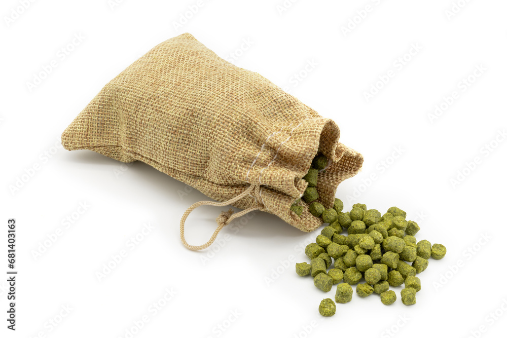 Small jute bag with pile of green hops pellets on white background.