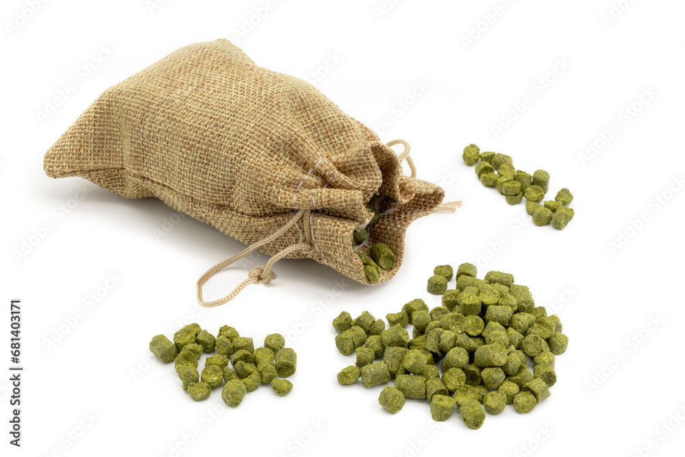 Small jute bag with pile of green hops pellets on white background.