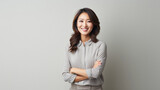 Confident asian business woman with arms crossed standing on grey background, asian.