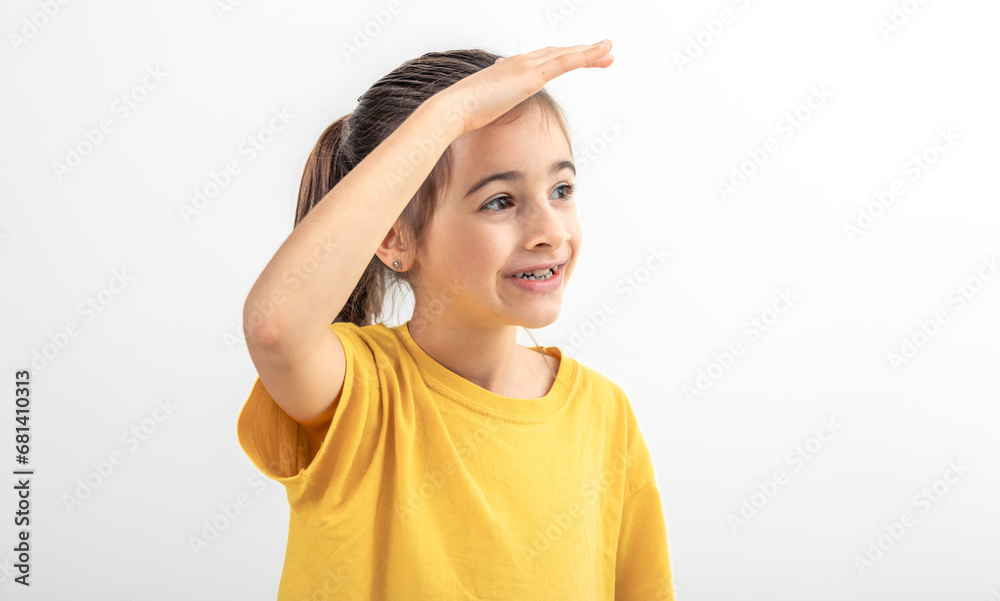 Little girl holding hand near forehead looking far away distance isolated. Little girl holding hand near forehead looking far away distance isolated.