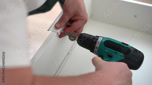 Wallpaper Mural Handyman drives a screw with a screwdriver in wooden furniture. Craftsman  Torontodigital.ca