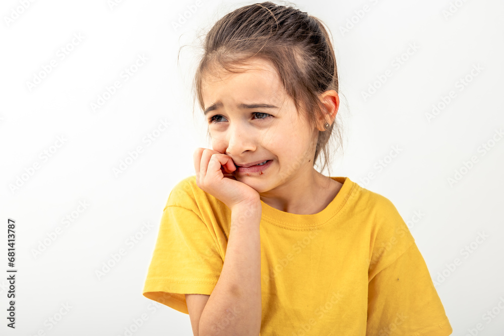 Scared and anxious girl, biting her fingernails on a white background isolated.