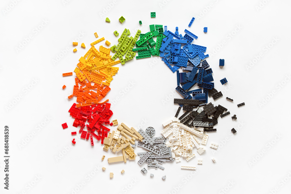 Obraz premium Pile of many various colorful rainbow colored stackable plastic toy bricks in circle shape on white background. Copy space. Top view. Lego blocks. Novosibirsk, Russia - October 26, 2023.
