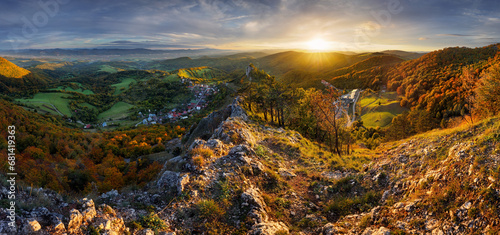 Mountains at sunset in Slovakia - Vrsatec. Landscape with mountain hills orange trees and grass in fall, colorful sky with golden sunbeams. Panorama