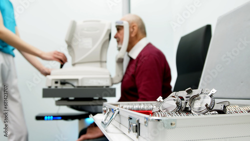 An elderly man undergoes an eye examination in a modern clinic. An expert checks vision using diagnostic ophthalmological equipment. photo