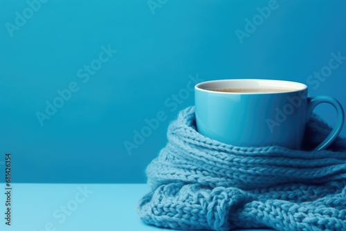 Cozy coffee cup wrapped in knit scarf. Blue Monday concept 