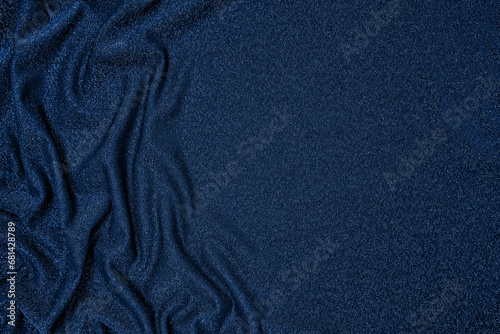 Trendy 80s, 90s, 2000s Background of draped dark blue fabric with silver lurex thread. Beautiful fashionable shiny fabric with a shiny thread for making clothes. Textile background texture.