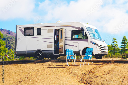 Beautiful tourism camper van campsite in the nature. Travel and rv renting vehicle vacation. Vanlife and wanderlust concept with modern motorhome parked in the nature with blue sky background
