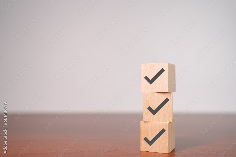 Check mark icons on wooden stacked blocks. Task lists, Checklist, Survey, Assessment, List, Confirm items, Double check, Quality Control. Goals achievement business success. Check mark icons on wooden stacked blocks. Task lists, Checklist, Survey, Assessment, List, Confirm items, Double check, Quality Control. Goals achievement business success.