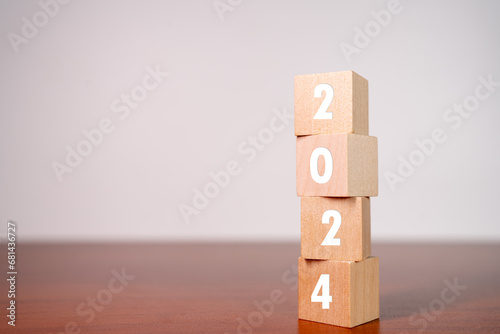 2024 Happy New year background banner. Two thousand Twenty-Four year numbers on wooden cube blocks stack on white background with copy space.