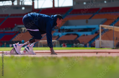 Disabled athletes prepare in starting position ready to run on stadium track © Wosunan