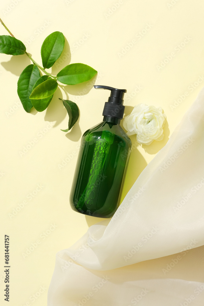 A bottle of green tea extract shampoo placed on a light background with fresh green tea leaves and camellia flowers. Blank label for design. Mockup for natural product advertising. A bottle of green tea extract shampoo placed on a light background with fresh green tea leaves and camellia flowers. Blank label for design. Mockup for natural product advertising.
