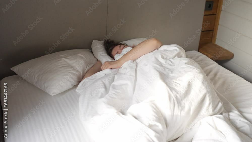 Female is sleeping cozily on a bed at the bedroom. Female is sleeping cozily on a bed at the bedroom.
