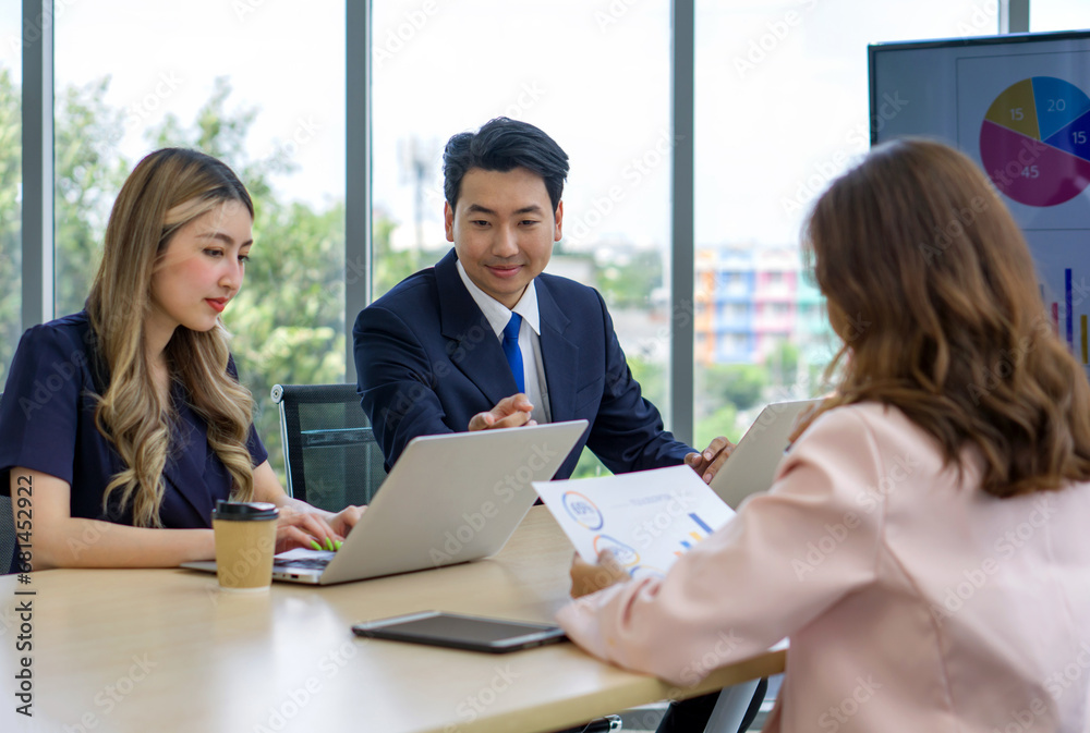 Some professionals are sitting together around a table, busy with their laptops during a meeting. Some professionals are sitting together around a table, busy with their laptops during a meeting.