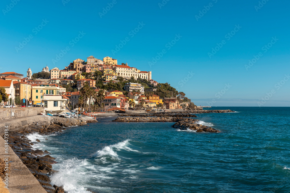 A beautiful village in Liguria on a promontory overlooking the sea. There are rocks and fishing boats.