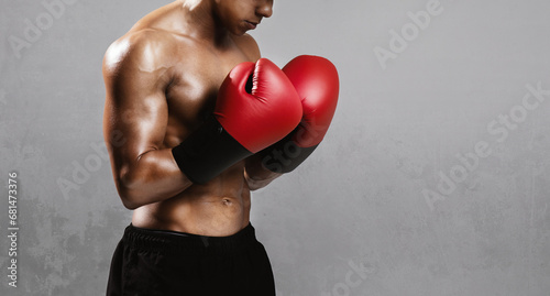 boxer standing with shirtless torso and red boxing gloves, studio