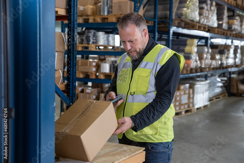 Employee scanning boxes in a distribution warehouse photo