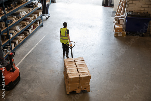 Worker in a warehouse using machinery to transport boxes
