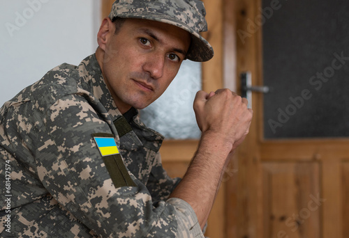 Upset military man sitting at home in thoughts.