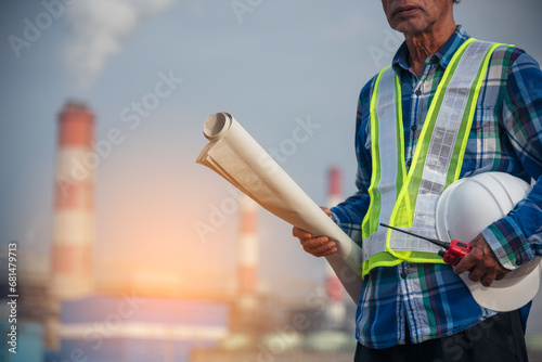 Senior Electrician engineer man hand holding red Walkie talkie communicate wear White hardhat at Power stations manufacturing electrical plant. Technician worker blue hard hat helmet Engineer industry
