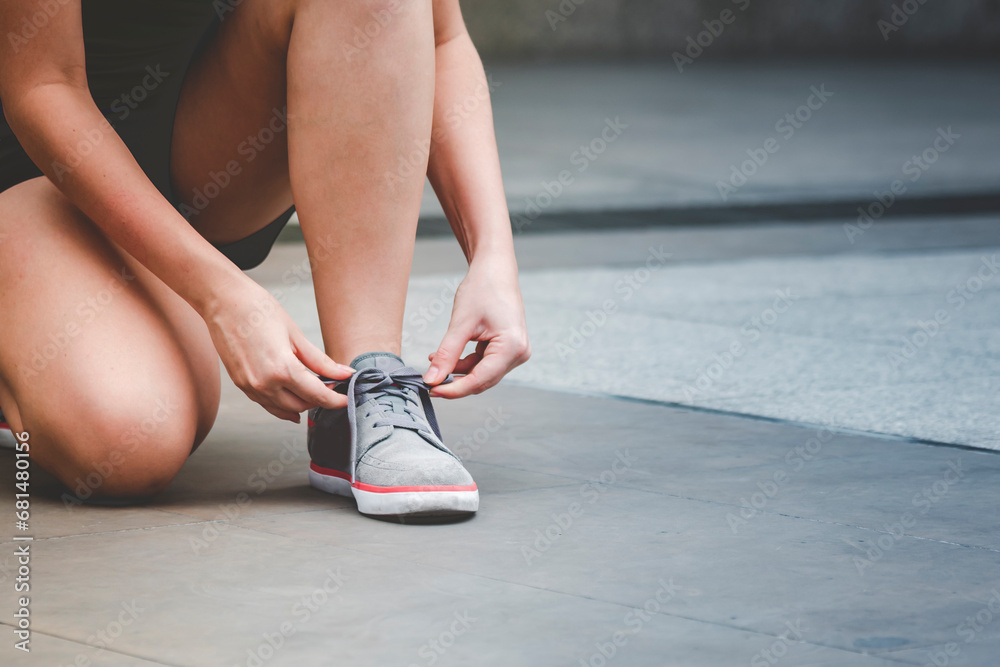 Sport sneakers footwear young woman knelt down do up shoelaces. Ready running shoes in sport exercise jogging person. Close up hands tie up runner shoelaces in fitness gym healthy person lifestyle. Sport sneakers footwear young woman knelt down do up shoelaces. Ready running shoes in sport exercise jogging person. Close up hands tie up runner shoelaces in fitness gym healthy person lifestyle.