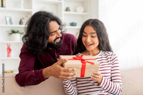 Loving young indian man greeting his excited pretty girlfriend
