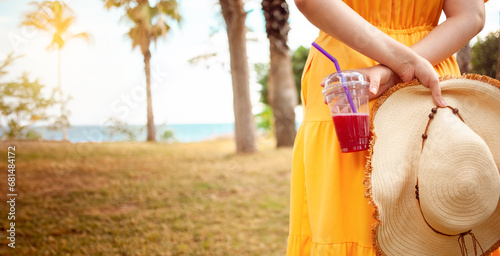Fotografia a woman in a summer hat relishes pomegranate juice