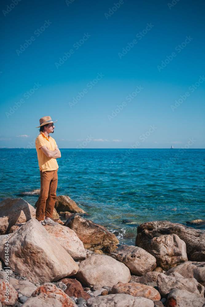 Elegance by the ocean: a stylish man, enjoying the journey's coastal allure