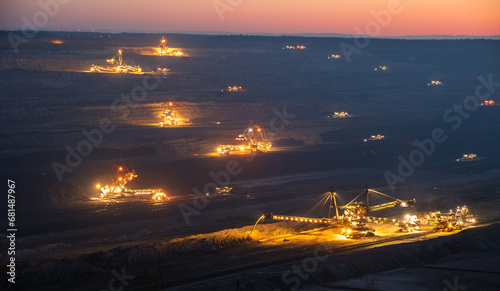 Photos Heavy mining equipment and machines at work in a brown coal open-pit mine at dusk
