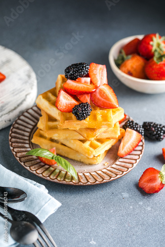 Waffles and Strawberries stacked on a plate. Belgian homemade waffles
