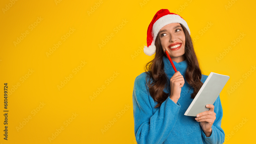 lady in Santa hat writes Christmas wish list in studio lady in Santa hat writes Christmas wish list in studio