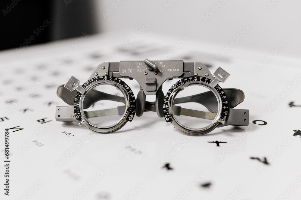Image of test glasses with letter diagram for eye examination, vision optometry background. Vision diagnostics and prevention concept. - obrazy, fototapety, plakaty 
