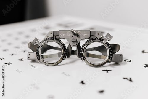 Image of test glasses with letter diagram for eye examination, vision optometry background. Vision diagnostics and prevention concept. photo