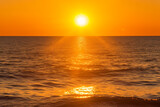 encapsulates striking moment of sun resting on sea's horizon, with its golden glow, gentle waves, and deep sense of calm that this celestial meeting inspires --v 5.1