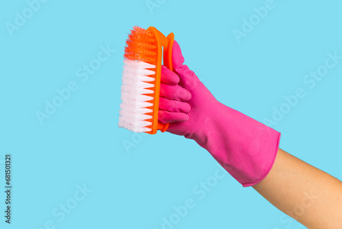 Brush for cleaning in hand. Women s hand cleaning on a colored background. Cleaning or housekeeping concepts.