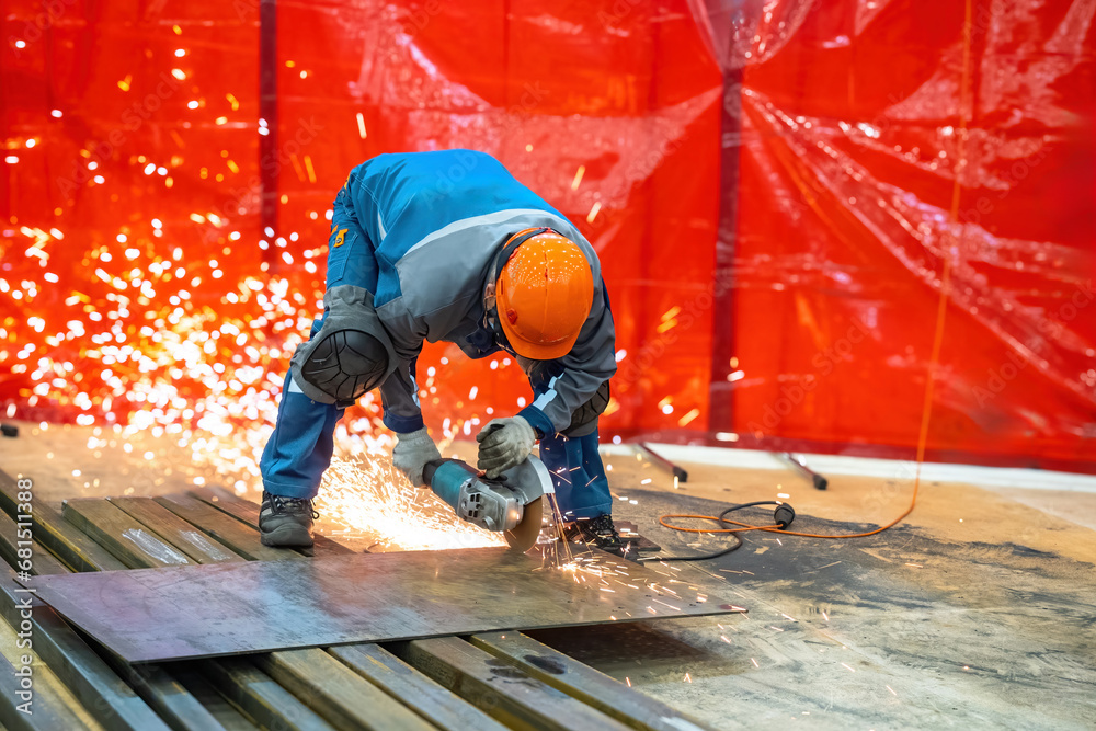 Construction works. Male craftsman with circular saw. Worker saws metal