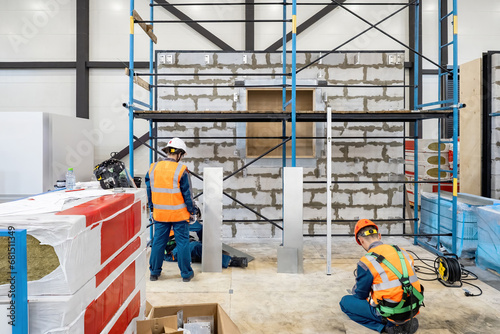 Builders work inside hangar...