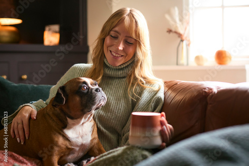 Canvas Print Woman At Home In Winter Jumper With Hot Drink Of Tea Or Coffee In Cup Stroking P