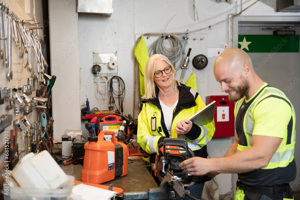 Male and female colleagues working in workshop Male and female colleagues working in workshop